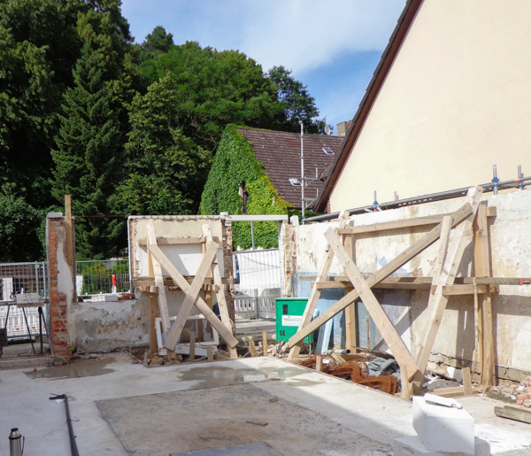 Baugrube mit Holzabstützungen zwischen den Nachbarhäusern